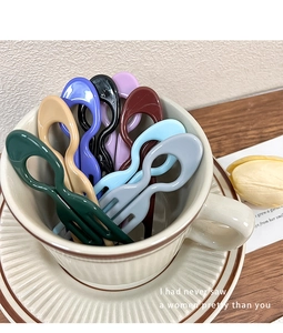 Close-up of minimalist U-shaped hairpins in eight vibrant colors inside a coffee cup