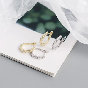 Macro shot of S925 sterling silver stamp on minimalist gold and silver U-shape hoop earrings