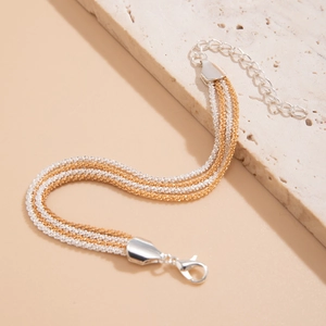 Close-up of multi-strand woven chain bracelet with silver lobster clasp and extender