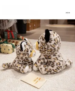 Close-up of small and large leopard plush toys on a soft rug in a warm cozy setting