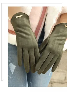 Detail view of olive green suede gloves featuring a gold metal buckle on the wrist