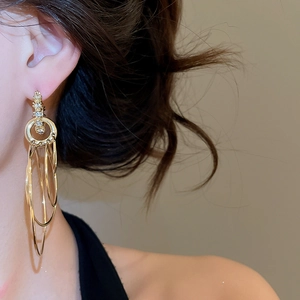 Primo piano di una modella che indossa orecchini a cerchio dorati a più strati con strass