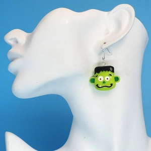 Detail showing a green Frankenstein Halloween earring worn on a model ear