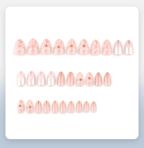 Flat lay of 3D embossed flower almond press-on nails with pearl finish and gold lines