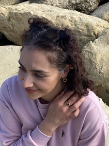 Gros plan extérieur de boucles d'oreilles cœur doré et bague vintage avec pierre