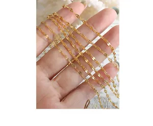 Close-up detail of a minimalist gold-plated titanium chain with textured link design