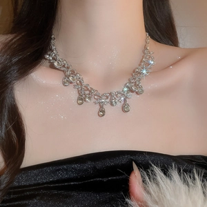 Close-up of elegant silver teardrop necklace with sparkling crystals on a model