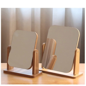 Detail of two rectangular wooden vanity mirrors in different sizes on a desk