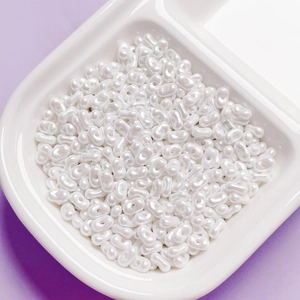 Close-up of pearl white peanut-shaped acrylic beads for DIY jewelry making accessories