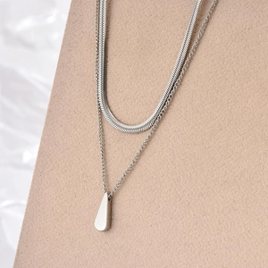 Detail of double-layer titanium steel necklace with water drop pendant and snake chain