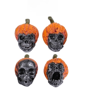 Detailed view of resin Halloween skulls wearing orange pumpkin hats with textured carvings