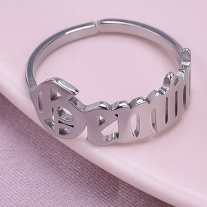 Detail of silver adjustable ring featuring hollowed out BEAUTIFUL letter design