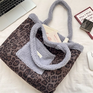 Macro detail of leopard print tote bag with soft grey plush handle and office accessories