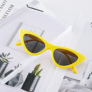 Stylish yellow cat-eye sunglasses with dark grey lenses on a minimalist background