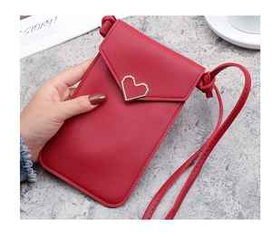 Dettaglio borsa porta cellulare rossa con fibbia a cuore dorata e tracolla sottile
