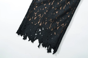 Close-up of intricate black lace texture with delicate hollow patterns and scalloped edges
