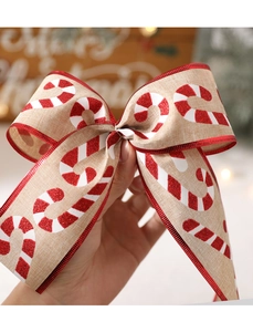 Close-up of beige linen Christmas bow featuring red sequin candy cane patterns