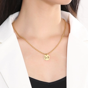 Close-up of gold beaded chain with family silhouette pendant on a female model