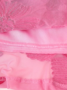 Close-up of pink mesh fabric with floral embroidery and refined seam stitching detail