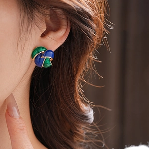 Detail of vintage leaf earrings with blue and green enamel and gold-plated edges