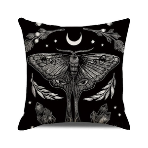 Macro shot of Halloween cushion cover with white moth, crescent moon, and stars pattern