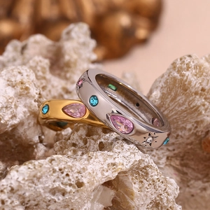 Close-up of gold and silver rings with colorful zircon drops and star engravings