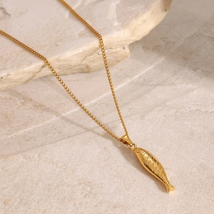 Detailed close-up of a golden fish pendant necklace with intricate scale texture