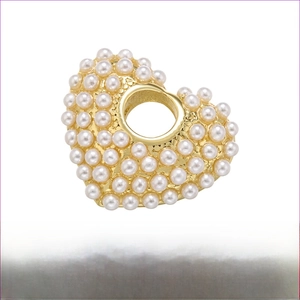 Detailed view of heart pendant featuring pearl inlay and rhodium-plated brass finish