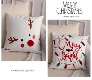Close-up of festive Christmas pillowcases with deer embroidery and holiday typography