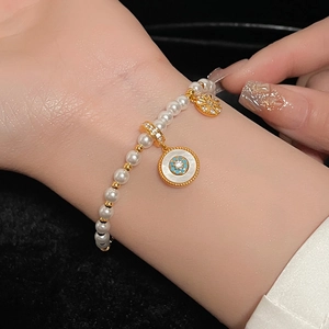 Bracelet de perles élégant avec pendentif étoile en émail bleu et breloques dorées