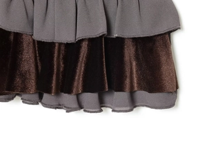 Detail of multi-layered ruffled hem in dark grey chiffon and velvet fabric texture