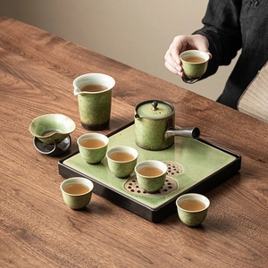 Chinese vintage green ceramic tea set with cups, teapot, and lotus tray on wood table