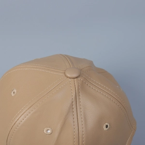 Close-up of khaki PU leather baseball cap featuring lychee grain texture and stitching