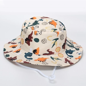 Détail du chapeau de soleil enfant avec motifs dinosaures et cordon réglable blanc