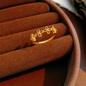 Gros plan détaillé d'une bague vintage dorée avec motif trèfle à quatre feuilles et milgrain