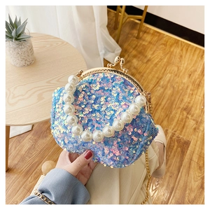 Close-up of blue sequin mini shell bag with pearl handle and golden metal frame