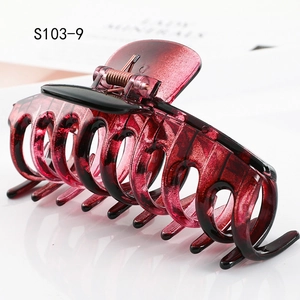 Macro side view of a large burgundy marble hair claw with secure metal spring detail