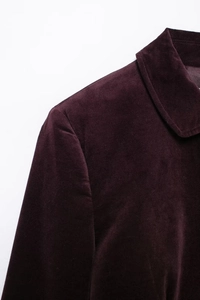 Détail du revers et de l'épaule d'une veste en velours bordeaux à texture riche
