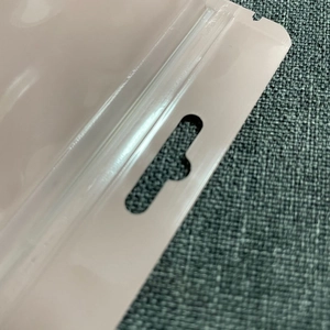 Close-up of pink resealable plastic pouch with hang hole for jewelry and phone cases