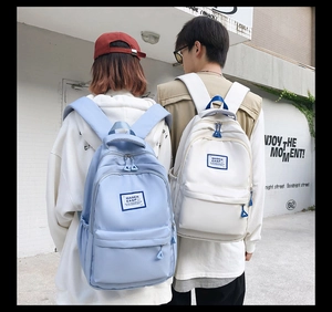 Outdoor shot of light blue and white large capacity canvas backpacks for students