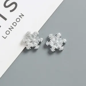 Macro shot of 17mm silver snowflake resin charm with detailed radial textures for DIY craft