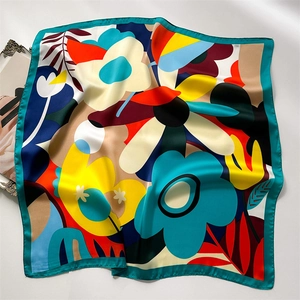 Macro detail of dopamine floral print silk scarf featuring vivid colors and satin texture
