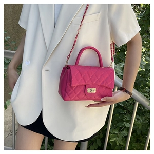 Detailed close-up of a pink quilted crossbody bag with a gold chain and metal lock