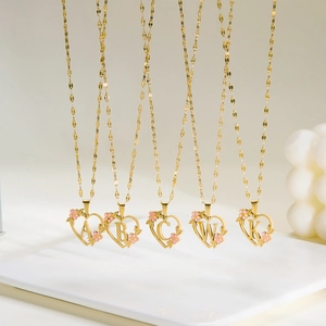 Gold stainless steel heart necklace featuring pink enamel flower and custom initial pendant