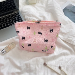 Pink fabric makeup bag with cute cat and pear patterns on a cozy lifestyle background