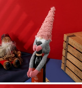 Pink gnome wine bottle cover with grey body in a festive Nordic Christmas setting