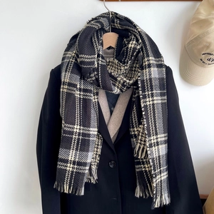 Détail d'une écharpe douce à carreaux noir et blanc avec franges pour tenue hivernale
