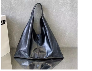 Détail du sac hobo en cuir PU noir souple avec finition huileuse sur table mate