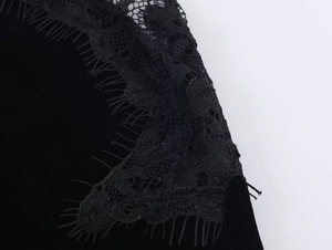 Detail von Wimpernspitze und Samtstoffnähten an einem schwarzen Partykleid für Damen