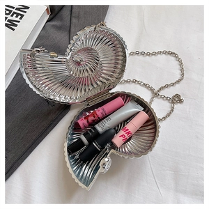 Macro detail of silver snail shell evening bag showing internal space for lipsticks
